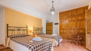 A room with two beds, a chair, and a wardrobe.