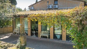Un bâtiment doté d’un patio couvert, d’un espace extérieur aménagé pour s’asseoir et de climatiseurs.