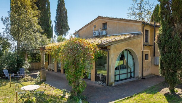 Un bâtiment doté d’un patio avec jardin, d’un espace extérieur aménagé pour s’asseoir et d’une pergola.