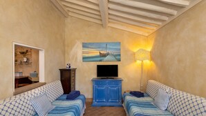A room with two beds, a television, a painting, and a lamp. - San Giovanni R. Apartment 1 Dantea with Private Garden, Wi-Fi, and Air Conditioning (Peccioli)