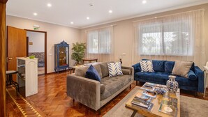 A living room with a sofa, a coffee table, and a cabinet. - Milreu Guesthouse - Room 'Mar' with Pool view (Estói)