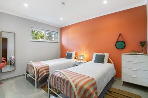 A bedroom with two beds, a dresser, a mirror, and a window. - Milreu Guesthouse - 70m² flat for 4 people (Estói)