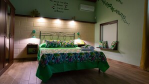 A bedroom with a bed, two bedside lamps, a wall-mounted air conditioner, and a decorative wall with text. - Holiday Home 'Ficurigna' with Private Garden, Wi-Fi and Air Conditioning (Marsala)