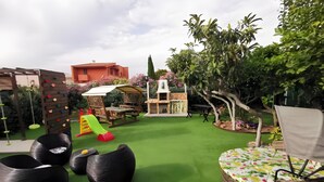 A garden with artificial grass, a climbing wall, a slide, and outdoor seating. - Holiday Home 'Ficurigna' with Private Garden, Wi-Fi and Air Conditioning (Marsala)