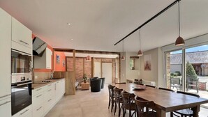 Una cocina moderna con comedor, ventanas amplias y vistas al exterior.