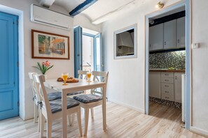 Un comedor con una mesa, sillas y un cuadro en la pared.