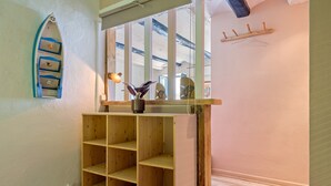 Una habitación con una estantería de madera, un adorno de barco en la pared y suelo de madera.