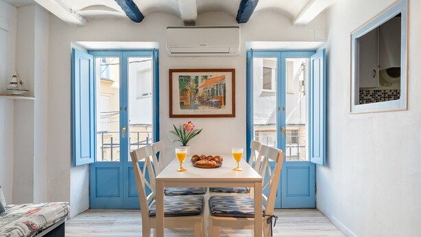 Un comedor con una mesa, sillas y una disposición para el desayuno.