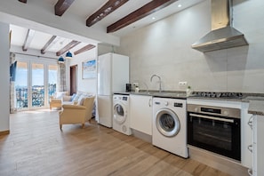 A modern kitchen with built-in appliances, a dining area with a view, and a laundry room.