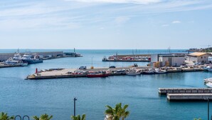 A marina with boats docked, a pier, and a building with a flat roof.