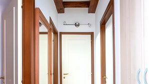 A hallway with wooden doors, a tiled floor, and a wooden ceiling. - Apartment 'Vista Lago 2' with Lake View, Shared Terrace and Wi-Fi (Cannobio)
