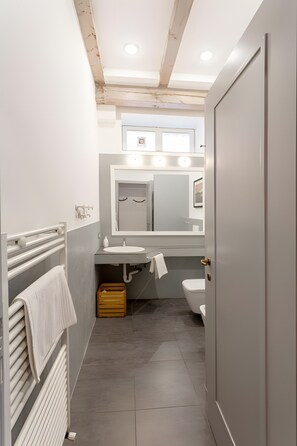 Ein modernes Badezimmer mit Toilette, Waschbecken und Handtuchhalter.
