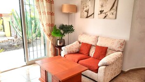 A living room with a sofa, a coffee table, a lamp, and two wall-mounted flower paintings. - Villa 'Ensueno with Private Pool' with Private Pool, Wi-Fi and Air Conditioning (Mazarrón)