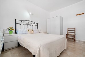 Une chambre à coucher comprenant un lit, des tables de chevet, une armoire et une chaise.