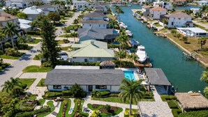 A residential area with a swimming pool, a boat dock, and a river. - 🏖️ Coastal Luxury Retreat | Private Pool & Spa • Walk to Vanderbilt Beach • Naples Park Gem (Naples)