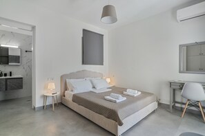 A modern bedroom with a bed, bedside tables, a desk, and a chair. - Studio Apartment 'Chakalaka -  with Sofa Bed 3' with Sea View, Wi-Fi and Air Conditioning (Leykada)