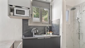 A modern kitchen with a microwave, sink, and cabinet. - Studio Apartment 'Chakalaka -  with Sofa Bed 4' with Mountain View, Wi-Fi and Air Conditioning (Leykada)