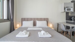 A hotel room with a bed, bedside lamps, a desk with a chair, and a microwave above the desk. - Studio Apartment 'Chakalaka -  with Sofa Bed 4' with Mountain View, Wi-Fi and Air Conditioning (Leykada)