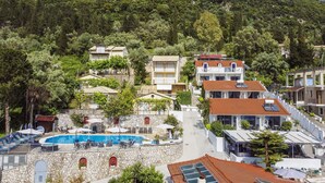 A hillside hotel with a swimming pool, multiple balconies, and a view of the surrounding forest. - Studio Apartment 'Chakalaka -  with Sofa Bed 4' with Mountain View, Wi-Fi and Air Conditioning (Leykada)