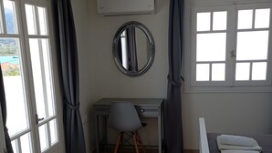 A bedroom with a bed, a desk, a chair, a window, and an air conditioning unit. - Apartment 'Chakalaka -  2 Bedrooms 5' with Sea View, Wi-Fi and Air Conditioning (Leykada)