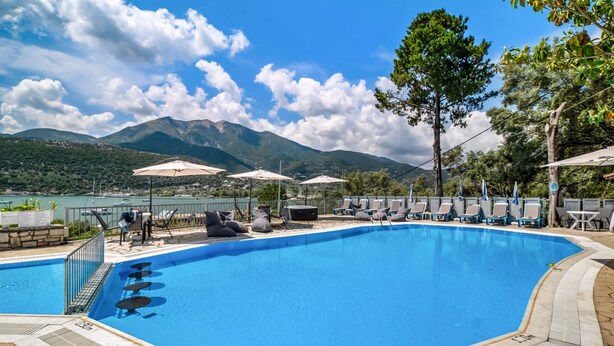 A swimming pool with lounge chairs and umbrellas, surrounded by mountains and trees. - Apartment 'Chakalaka -  2 Bedrooms 5' with Sea View, Wi-Fi and Air Conditioning (Leykada)