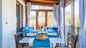 A dining area with a table set for two, a bottle of wine, and a plate of food.