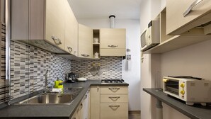 Een moderne keuken met een ingebouwde magnetron, broodrooster en gasfornuis.