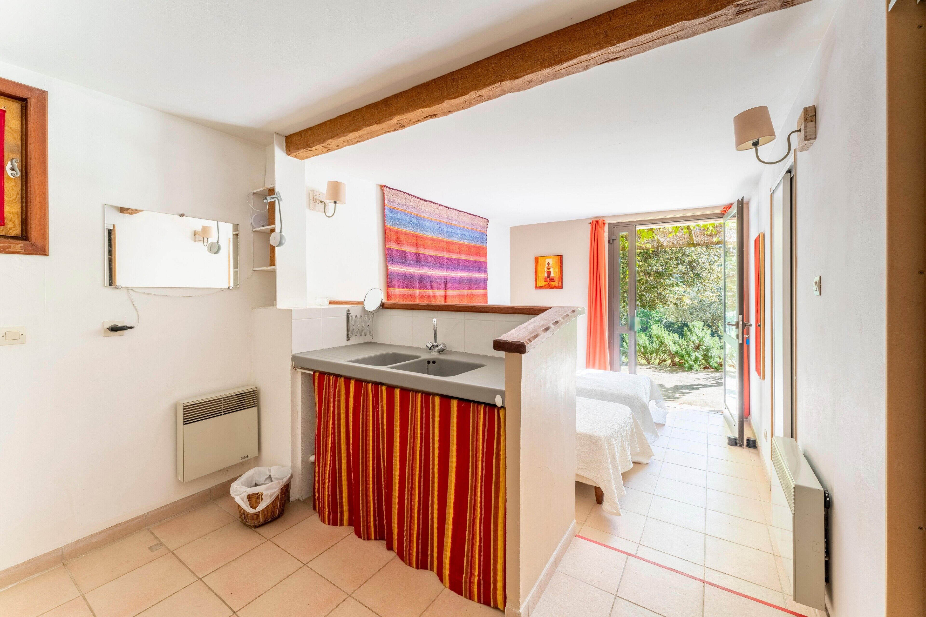 Een keuken met een spoelbak, een radiator en een raam.