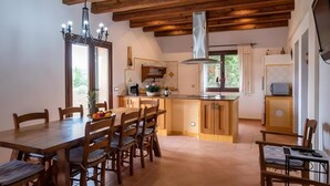 A spacious kitchen with wooden cabinets, a central island, and a dining area with a wooden table and chairs.