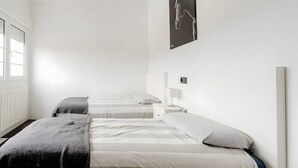 A room with two beds, a window, a wall-mounted picture, and a bedside table with a lamp. - Chalet 'Alarpe Aterpetxea' with Mountain Views, Shared Terrace and Garden (Zaldibia)
