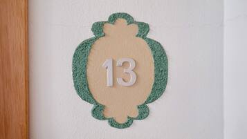 A wall-mounted number plate with the number 13.