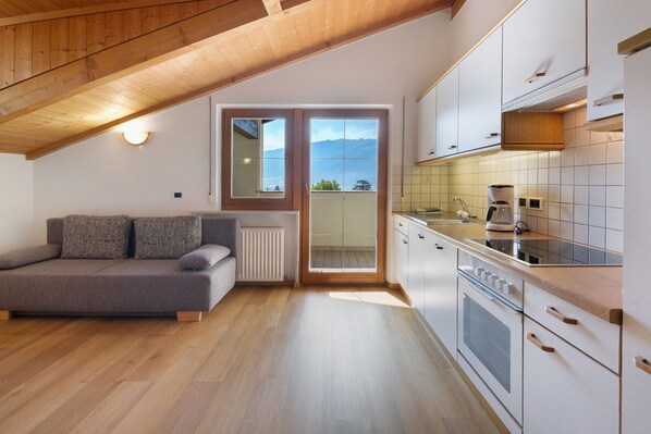 A modern kitchen with a built-in oven, a coffee maker, and a view through the door.