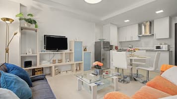 Una sala de estar moderna con un sofá, una mesa de centro y una televisión.