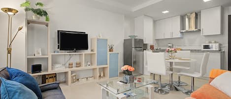 Un salon moderne avec un canapé, une table basse et un téléviseur.