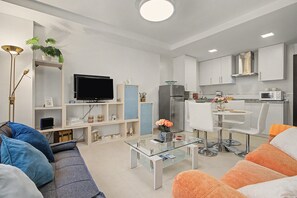 A modern living room with a sofa, coffee table, and a television.