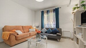 Uma sala de estar com sofá, mesa de centro e televisão.
