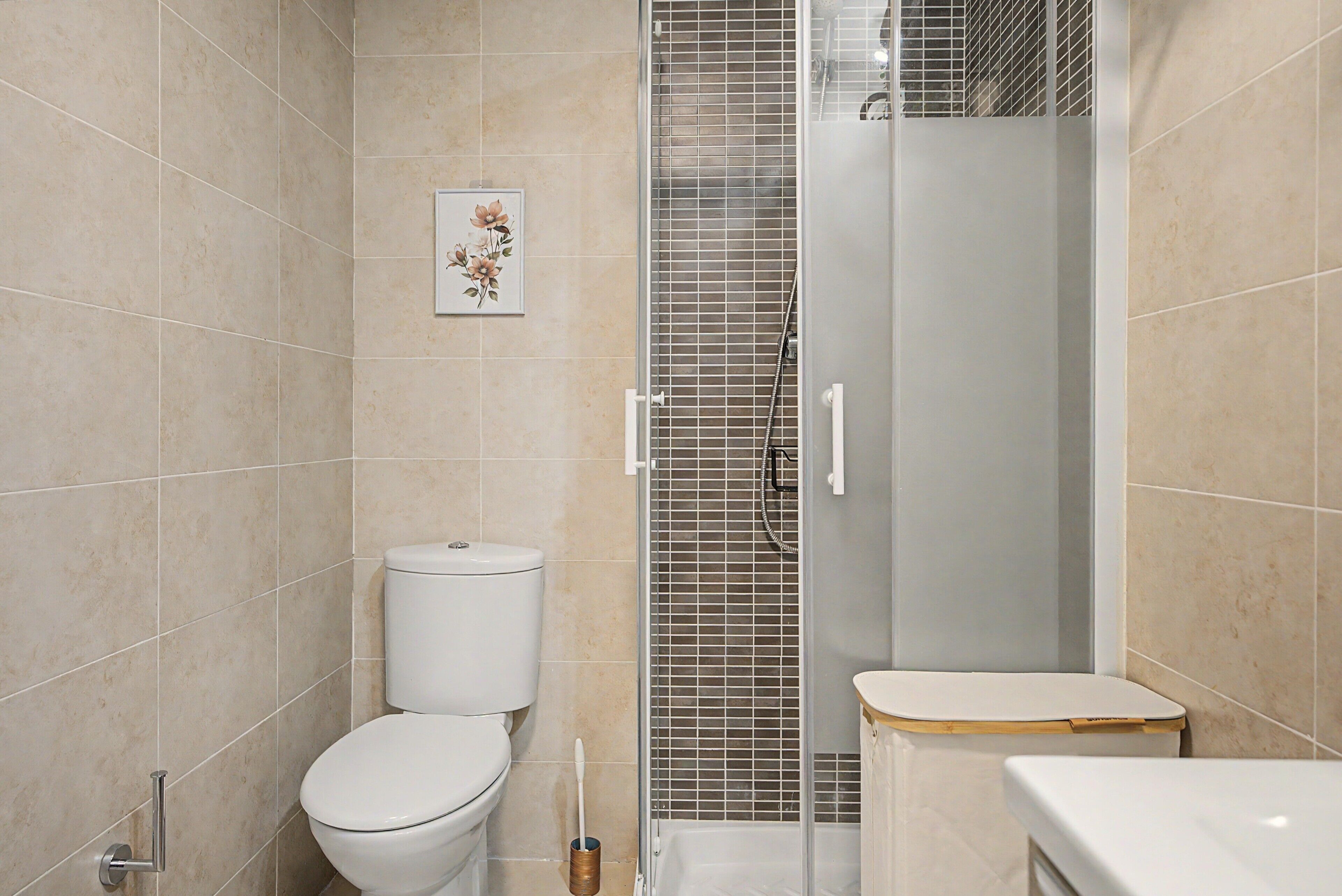 Une salle de bain comprenant des toilettes, un espace douche et un lavabo.