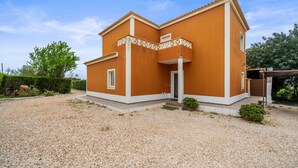 Ein zweistöckiges Haus mit Kopfsteinpflaster-Einfahrt und einem kleinen Garten.