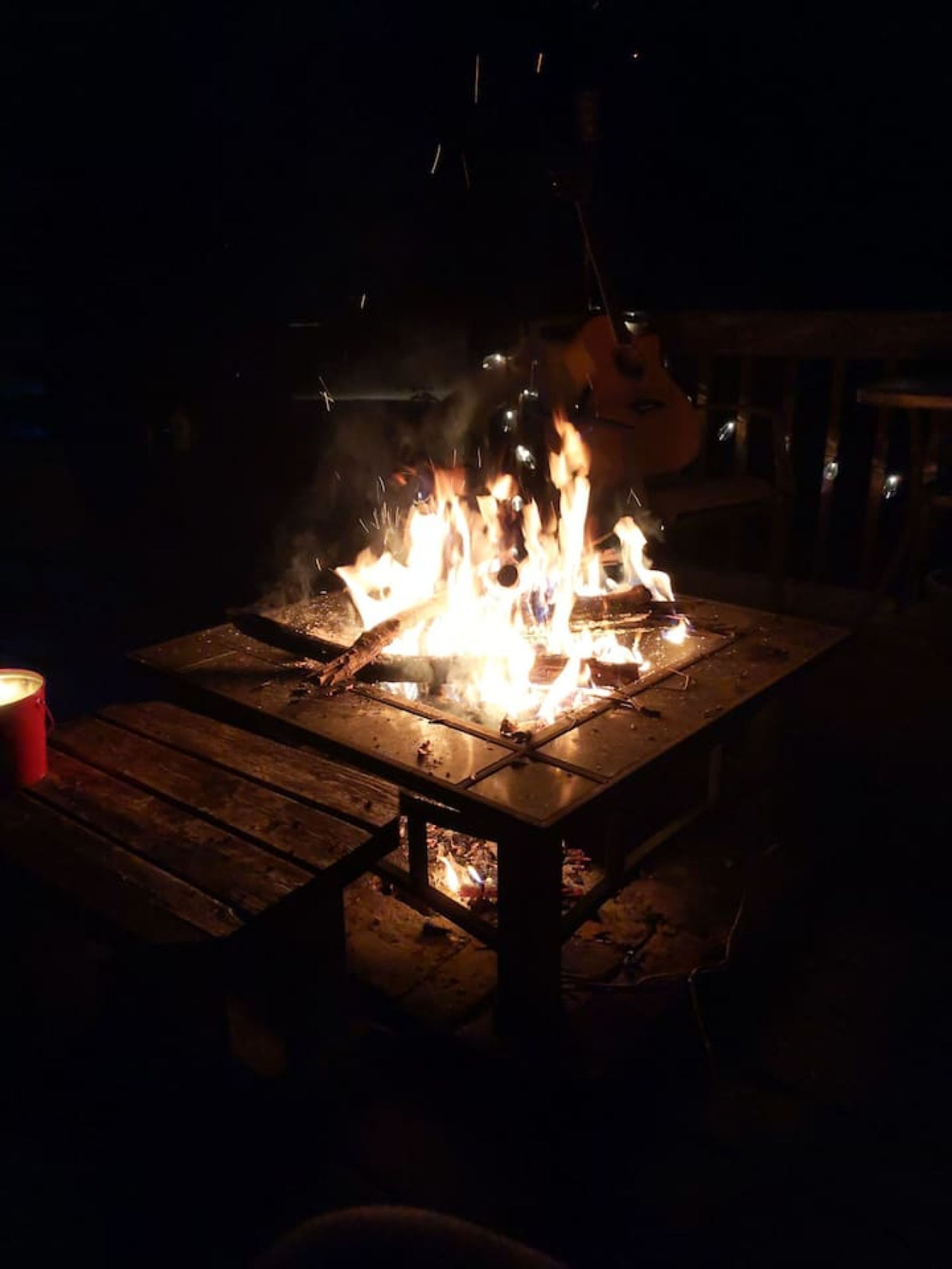 A campfire on a wooden table at night.