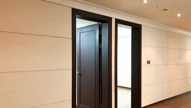 A hallway with wooden flooring and a dark door. - Sejong Party House  (Busan)