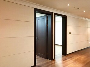 A hallway with wooden flooring and a dark door. - Sejong Party House  (Busan)