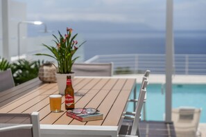 Una mesa de madera con una botella de cerveza, un vaso y un libro.