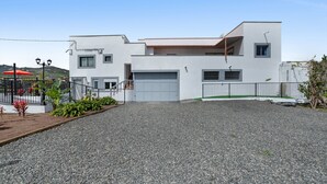 A modern two-story house with a white exterior, a garage, and a gravel driveway. - ‘Hacienda Los Adejo’ with Heated Private Pool, Mountain Views, and Wi-Fi (Moya)