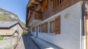 A traditional wooden building with balconies, a stone wall, and a clear view of a mountainous landscape. - Chalet 'Les Laouchets -  8 Pers' with Mountain View, Balcony and Wi-Fi (Sixt-Fer-à-Cheval)