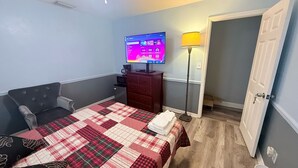 Une chambre d’hôtel comprenant un lit, un bureau, une chaise, une télévision et une lampe.