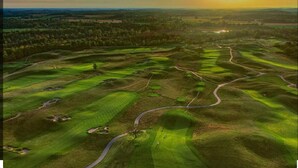 Un parcours de golf avec des allées sinueuses et différentes zones verdoyantes.