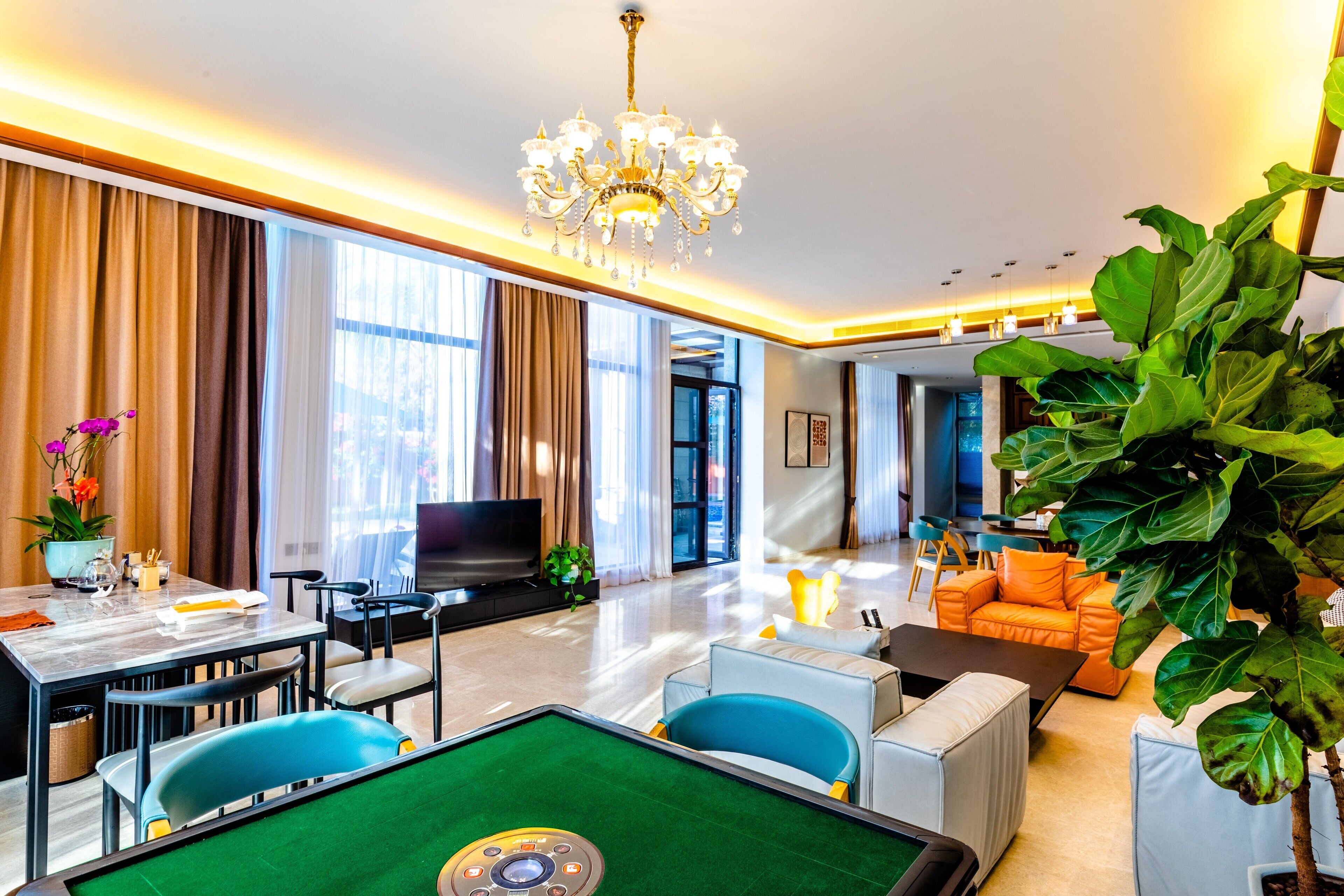 A modern hotel room with a pool table, a television, and a comfortable seating area.