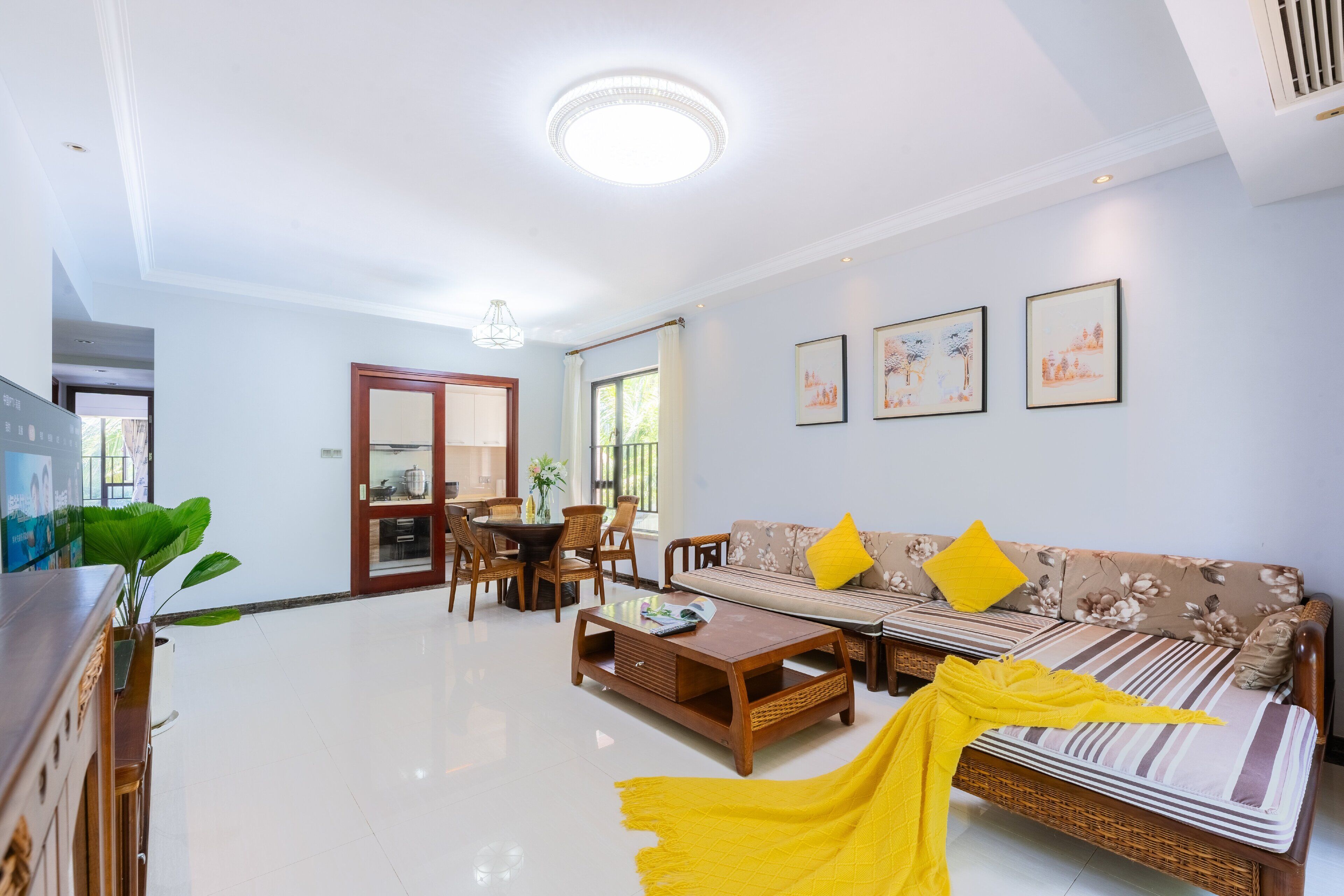 A modern living room with a sofa, coffee table, and dining area.