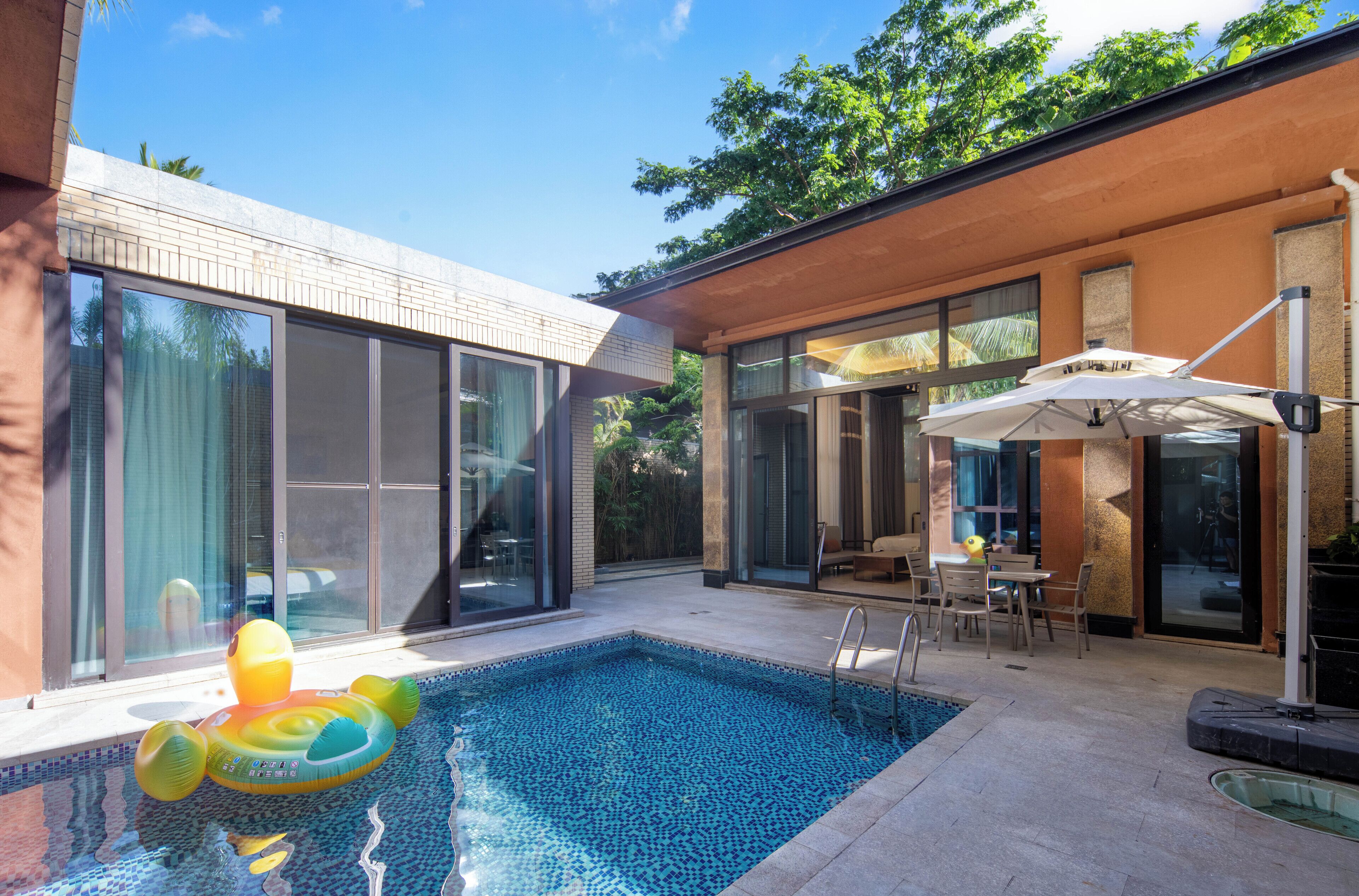 A modern house with a swimming pool, large windows, and outdoor furniture.