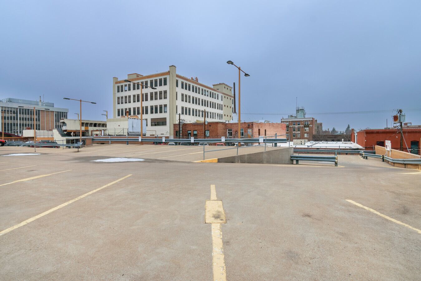 Un parking vide avec un bâtiment en arrière-plan.